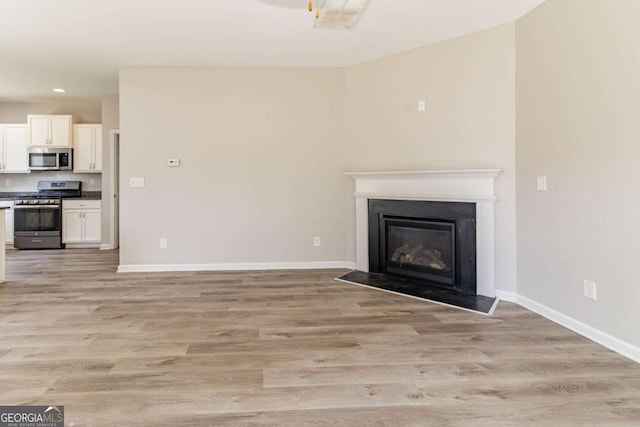 6399 Woodwell Dr, Union City, GA 30291 - unfurnished living room featuring light wood-style floors, recessed lighting, and a glass covered fireplace