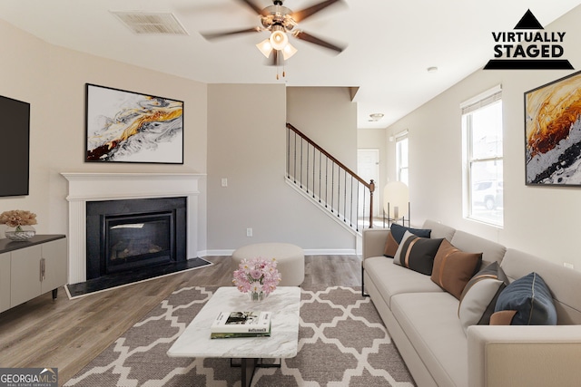 6399 Woodwell Dr, Union City, GA 30291 - living room featuring stairway, wood finished floors, a ceiling fan, and a glass covered fireplace
