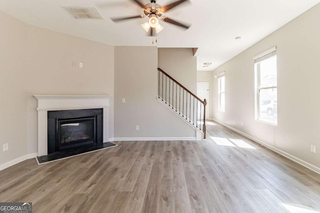 6399 Woodwell Dr, Union City, GA 30291 - unfurnished living room featuring stairway, a ceiling fan, wood finished floors, and a glass covered fireplace