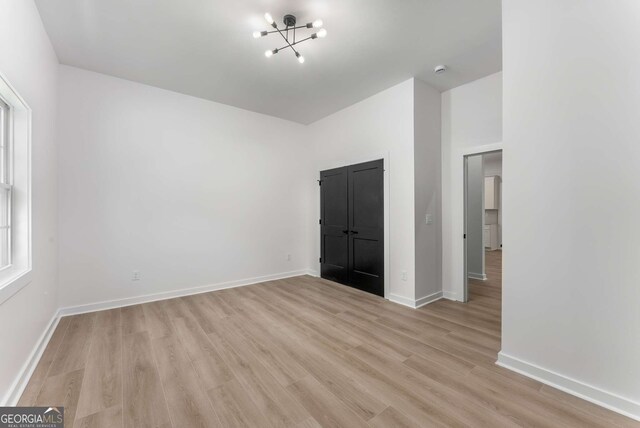 1569 Montreat Ave SW, Atlanta, GA 30311 - empty room featuring light wood-style flooring, baseboards, and an inviting chandelier