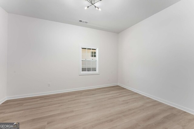 1569 Montreat Ave SW, Atlanta, GA 30311 - spare room featuring light wood-style floors, visible vents, baseboards, and an inviting chandelier
