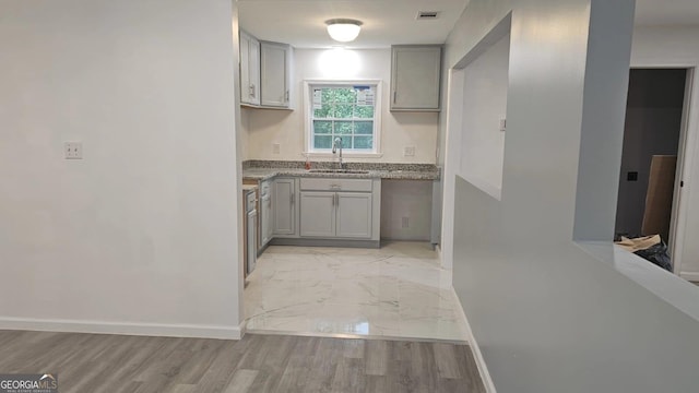 3685 Rice Mill Rd, Macon, GA 31206 - kitchen featuring a sink, gray cabinets, baseboards, and light marble finish flooring