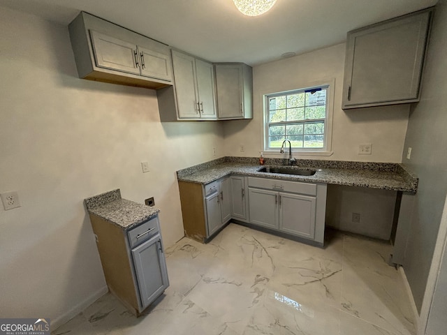 3685 Rice Mill Rd, Macon, GA 31206 - kitchen with gray cabinetry, a sink, light marble finish flooring, and baseboards