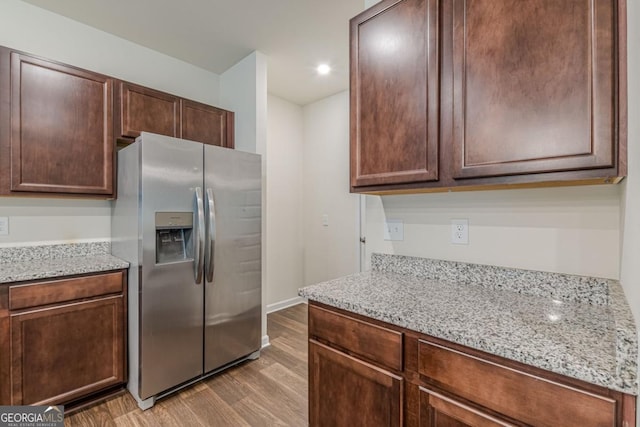 9061 Jim Purcell Dr, Covington, GA 30014 - kitchen featuring stainless steel fridge, wood finished floors, light stone countertops, dark brown cabinets, and recessed lighting