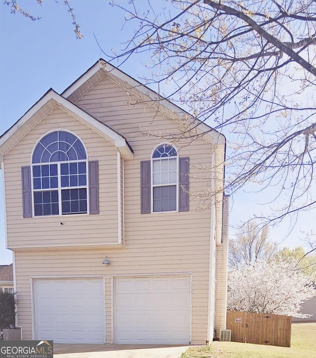 view of front of home with a garage, driveway, and fence