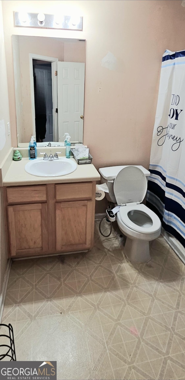 full bathroom featuring toilet, vanity, and a shower with curtain