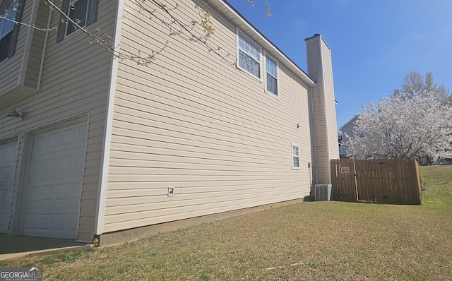 view of property exterior featuring a garage, a yard, central air condition unit, and fence