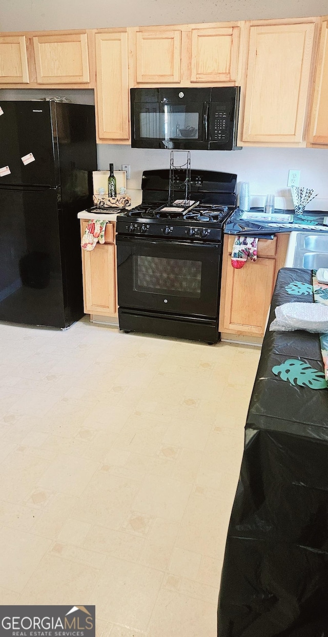 kitchen featuring light brown cabinets, black appliances, and light floors