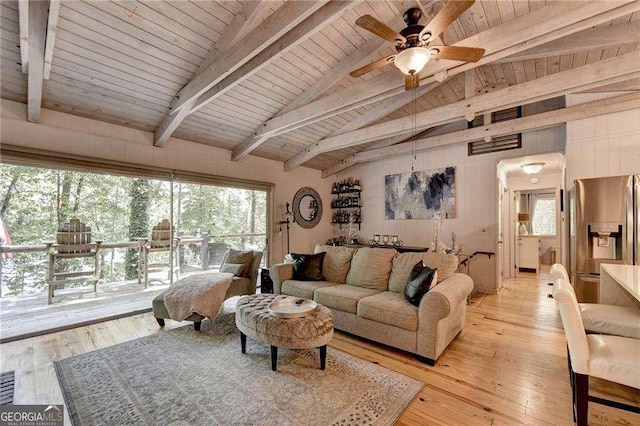 living area with lofted ceiling with beams, light wood finished floors, ceiling fan, and plenty of natural light