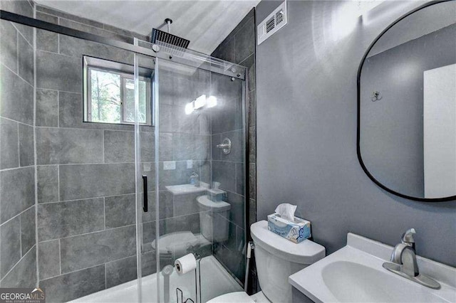 full bath with toilet, vanity, a shower stall, and visible vents
