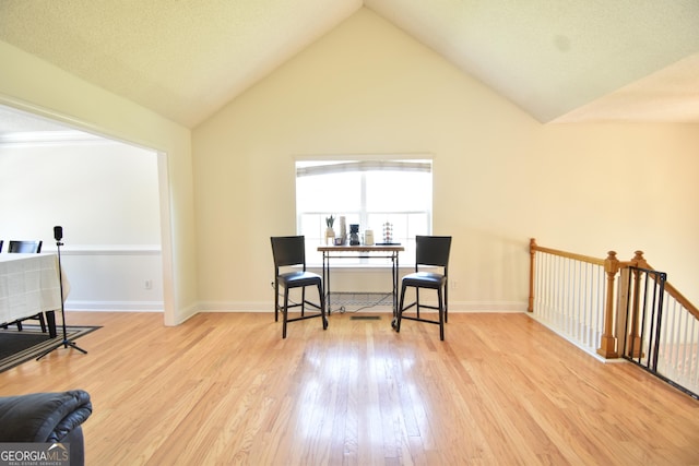 sitting room featuring lofted ceiling, wood finished floors, and baseboards