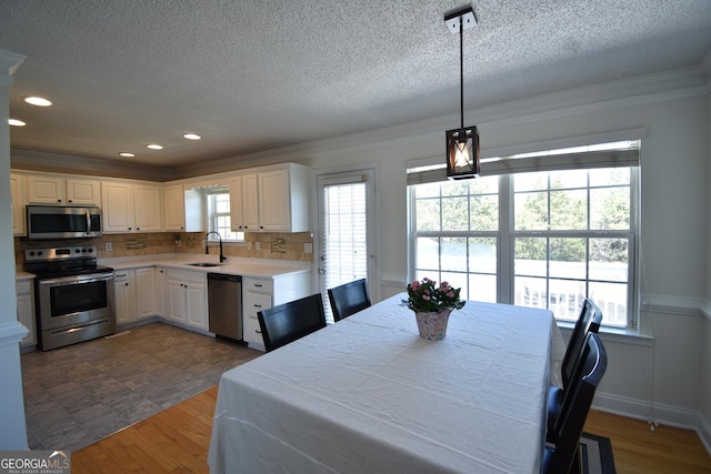 dining room with crown molding, recessed lighting, a textured ceiling, and dark wood-style flooring