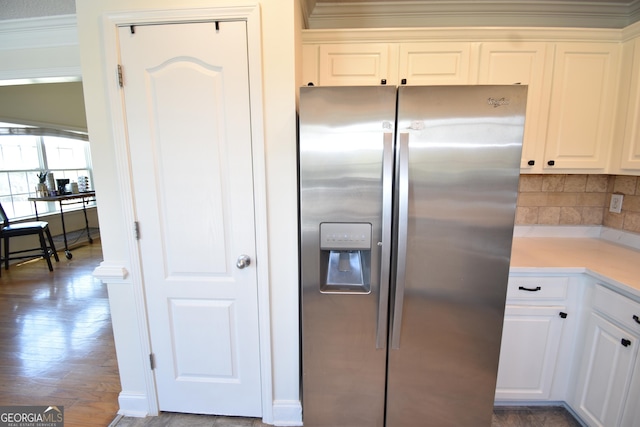 kitchen featuring white cabinetry, stainless steel refrigerator with ice dispenser, light countertops, and decorative backsplash