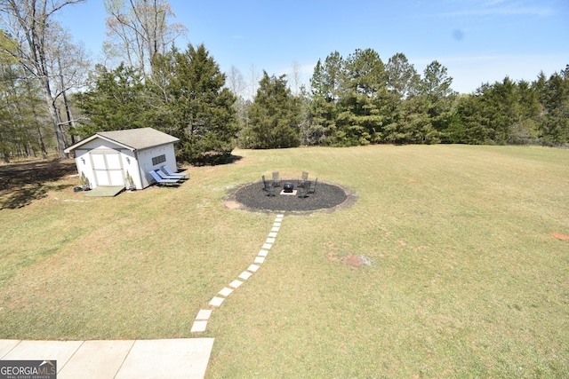 view of yard with a fire pit, an outbuilding, and a storage shed