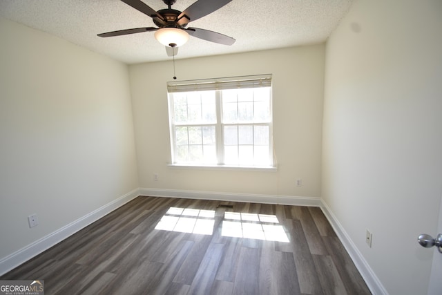 spare room with baseboards, dark wood-style floors, visible vents, a ceiling fan, and a textured ceiling