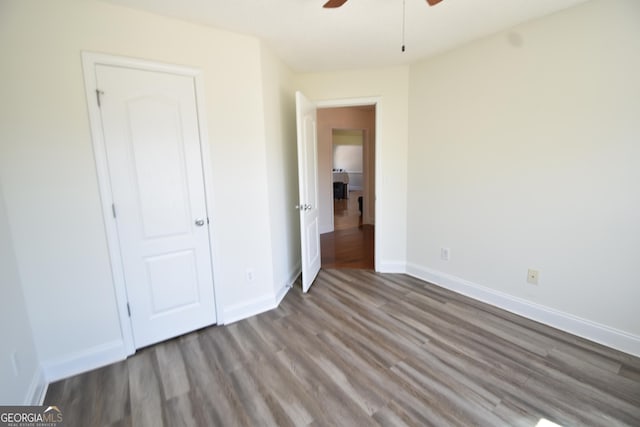 unfurnished bedroom featuring baseboards, wood finished floors, and a ceiling fan