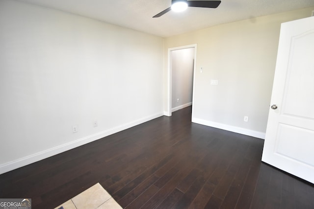 empty room featuring dark wood-style floors, ceiling fan, and baseboards