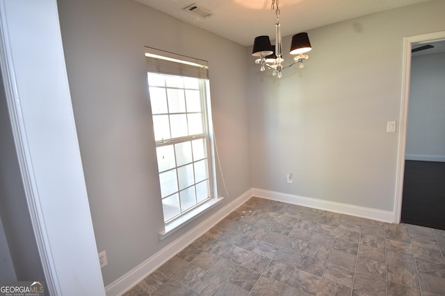 unfurnished dining area featuring baseboards, a wealth of natural light, and an inviting chandelier