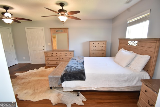 bedroom featuring wood finished floors, ceiling fan, and visible vents
