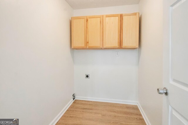 4785 Beaver Rd, Loganville, GA 30052 - washroom with baseboards, cabinet space, light wood finished floors, and electric dryer hookup