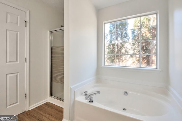 4785 Beaver Rd, Loganville, GA 30052 - full bathroom featuring a shower stall, wood finished floors, and a garden tub