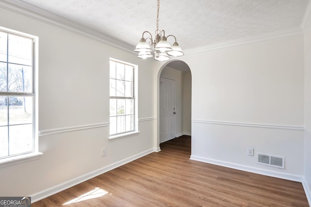 4785 Beaver Rd, Loganville, GA 30052 - unfurnished dining area with visible vents, a chandelier, ornamental molding, wood finished floors, and arched walkways