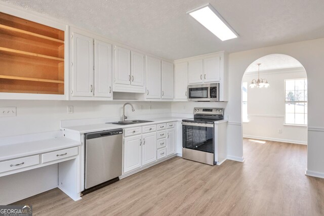 4785 Beaver Rd, Loganville, GA 30052 - kitchen with white cabinets, a sink, arched walkways, and appliances with stainless steel finishes