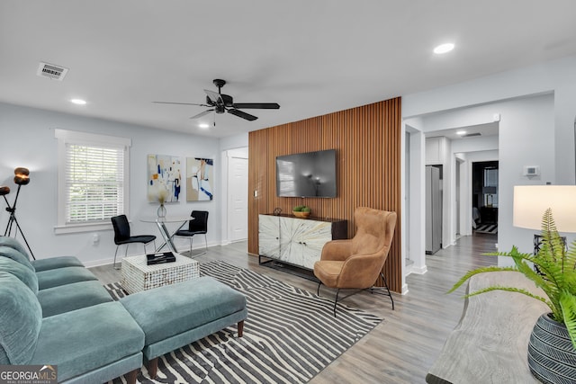 2535 Judson Ave, East Point, GA 30344 - living area featuring a ceiling fan, baseboards, visible vents, an accent wall, and wood finished floors