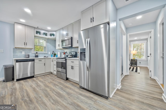 2535 Judson Ave, East Point, GA 30344 - kitchen featuring light countertops, appliances with stainless steel finishes, light wood-style flooring, and backsplash