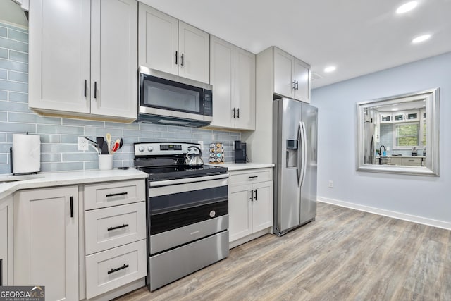 2535 Judson Ave, East Point, GA 30344 - kitchen featuring light countertops, stainless steel appliances, light wood-style flooring, and tasteful backsplash