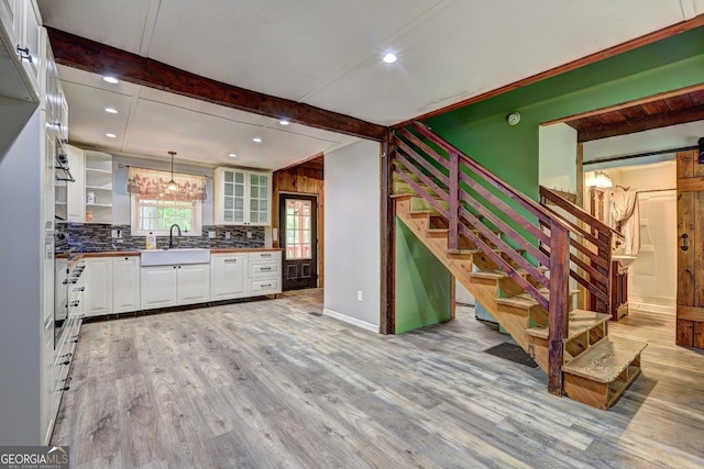 12 John Boy Trl, Newnan, GA 30263 - kitchen with a sink, white cabinetry, light wood-type flooring, backsplash, and beam ceiling