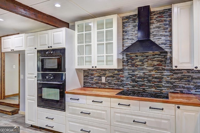 12 John Boy Trl, Newnan, GA 30263 - kitchen with wooden counters, wall chimney exhaust hood, black appliances, beamed ceiling, and glass insert cabinets