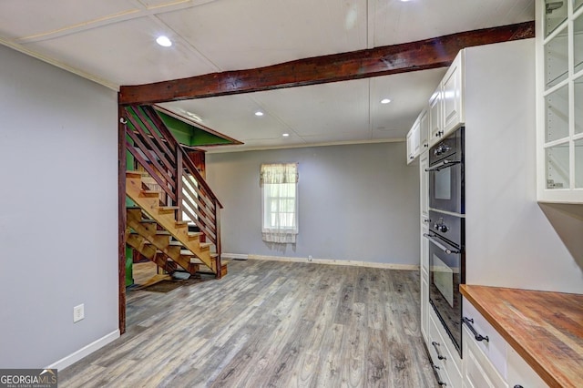 12 John Boy Trl, Newnan, GA 30263 - unfurnished living room featuring beamed ceiling, light wood-type flooring, baseboards, stairway, and recessed lighting