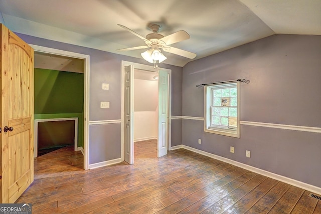 12 John Boy Trl, Newnan, GA 30263 - unfurnished bedroom featuring dark wood-type flooring, baseboards, lofted ceiling, and a ceiling fan