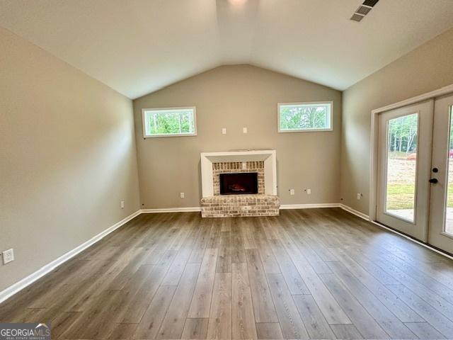 149 Sagebrook Ln Lot 8, Newnan, GA 30263 - unfurnished living room featuring a fireplace, dark wood-style flooring, healthy amount of natural light, baseboards, and lofted ceiling