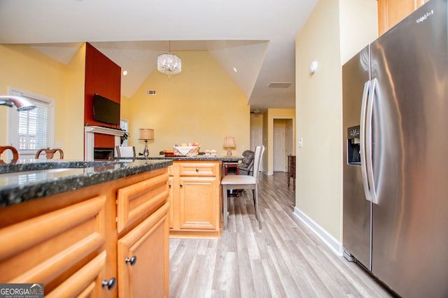 207 Meadow Lake Dr, Carrollton, GA 30116 - kitchen with stainless steel fridge with ice dispenser, light wood-type flooring, a chandelier, a fireplace, and dark stone counters