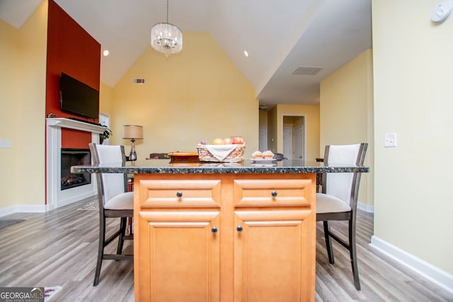 207 Meadow Lake Dr, Carrollton, GA 30116 - kitchen featuring a kitchen breakfast bar, light wood-style floors, a chandelier, and lofted ceiling