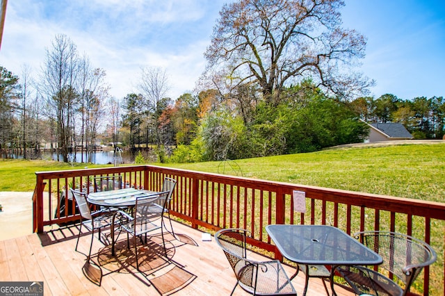 207 Meadow Lake Dr, Carrollton, GA 30116 - wooden deck featuring outdoor dining space, a water view, a lawn, and view of scattered trees