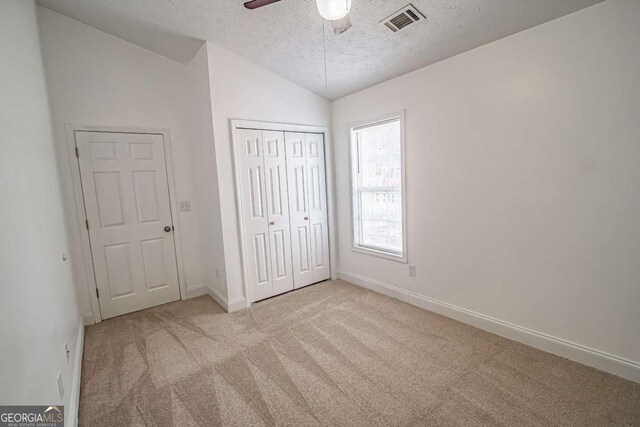 107 Griffith St, Winder, GA 30680 - unfurnished bedroom with visible vents, lofted ceiling, baseboards, a textured ceiling, and carpet flooring
