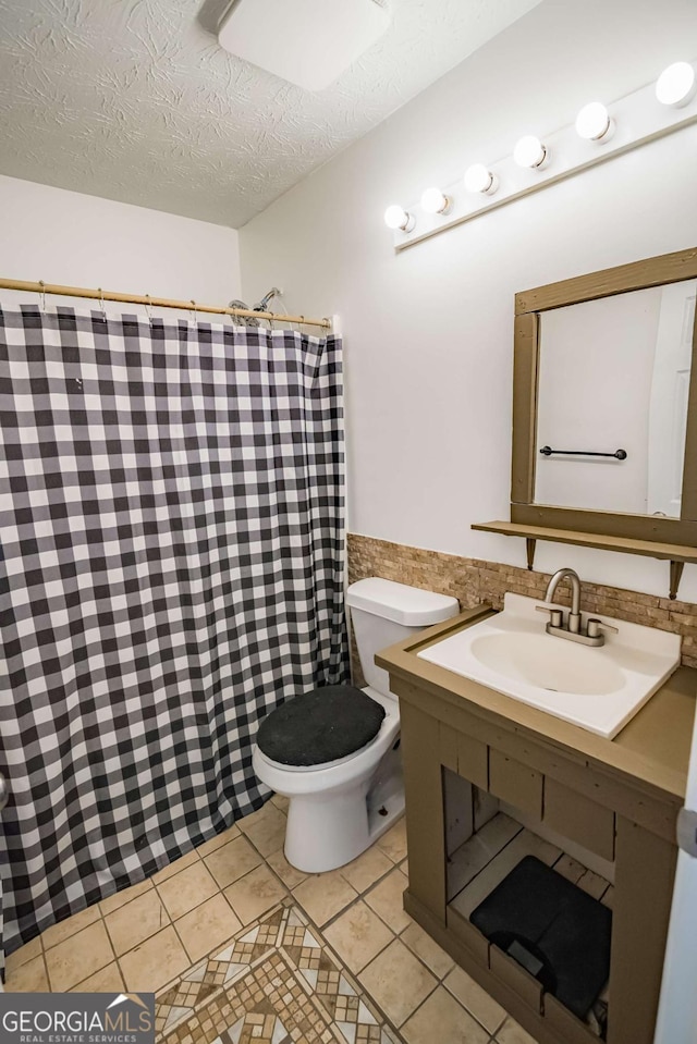107 Griffith St, Winder, GA 30680 - bathroom with a textured ceiling, curtained shower, tile patterned floors, vanity, and toilet