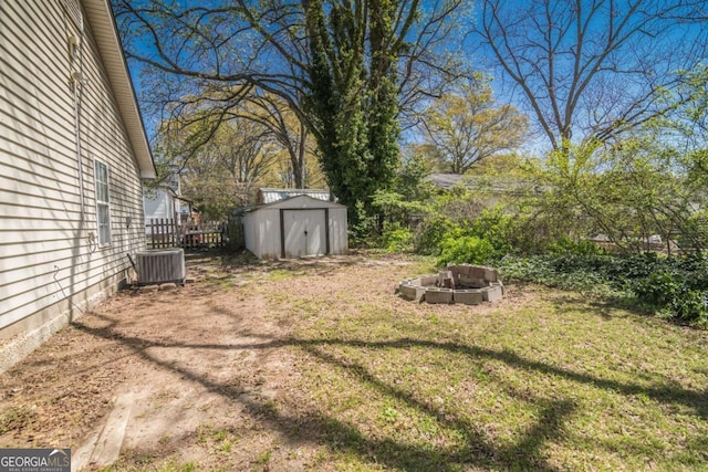 107 Griffith St, Winder, GA 30680 - view of yard featuring fence, a storage unit, central AC unit, an outdoor fire pit, and an outbuilding