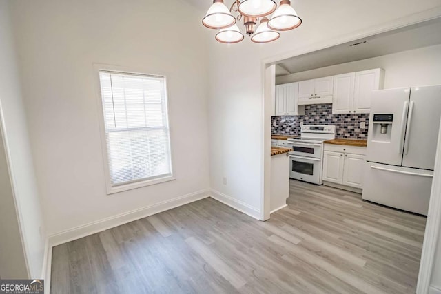 107 Griffith St, Winder, GA 30680 - kitchen featuring range with two ovens, white cabinets, light wood finished floors, a notable chandelier, and white fridge with ice dispenser