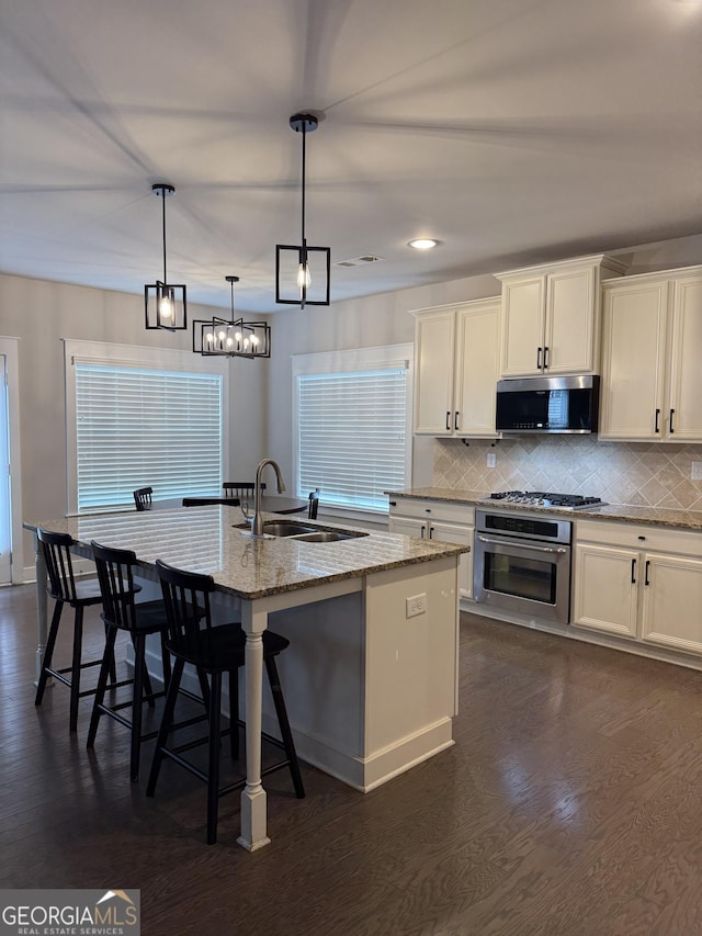 2470 Wevok Way, Grayson, GA 30017 - kitchen featuring appliances with stainless steel finishes, dark wood-style floors, a sink, and light stone counters