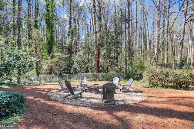1135 Parkview Way, Lilburn, GA 30047 - view of yard with a wooded view, a fire pit, and fence