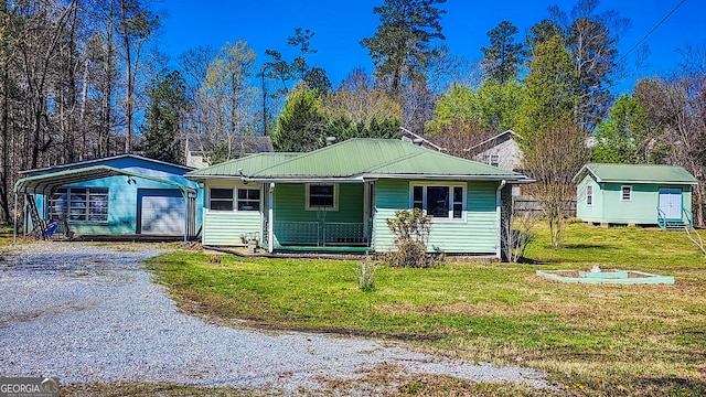 438 Wilkerson Rd SW, Rome, GA 30165 - view of front of house featuring a front yard, a porch, driveway, metal roof, and a fire pit