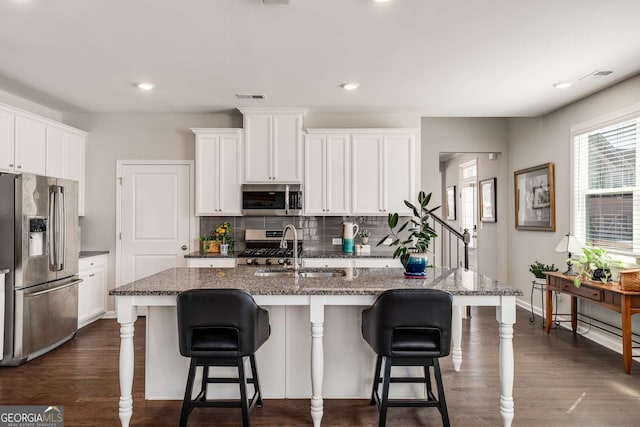 2910 Bishopstone Way, Cumming, GA 30040 - kitchen featuring tasteful backsplash, visible vents, a sink, dark wood-style floors, and stainless steel appliances