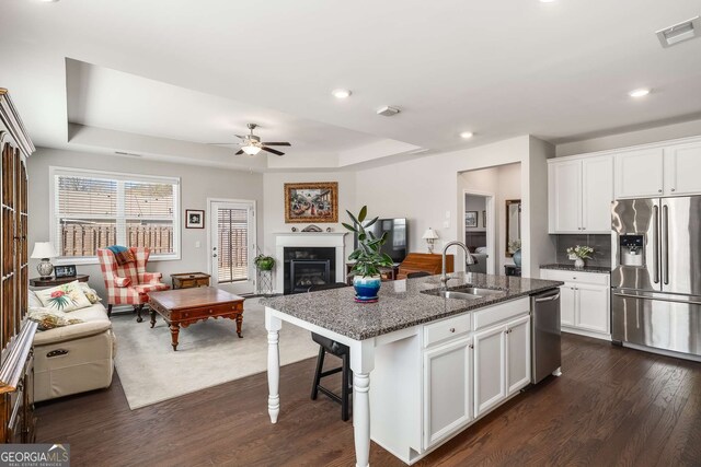 2910 Bishopstone Way, Cumming, GA 30040 - kitchen featuring visible vents, a sink, open floor plan, appliances with stainless steel finishes, and dark stone counters