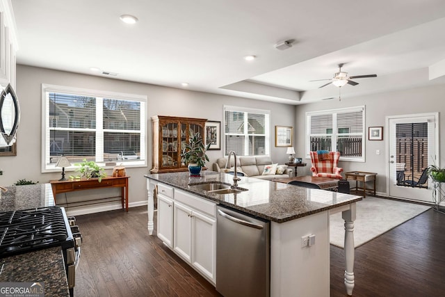 2910 Bishopstone Way, Cumming, GA 30040 - kitchen featuring dark stone counters, dark wood-type flooring, appliances with stainless steel finishes, a sink, and open floor plan