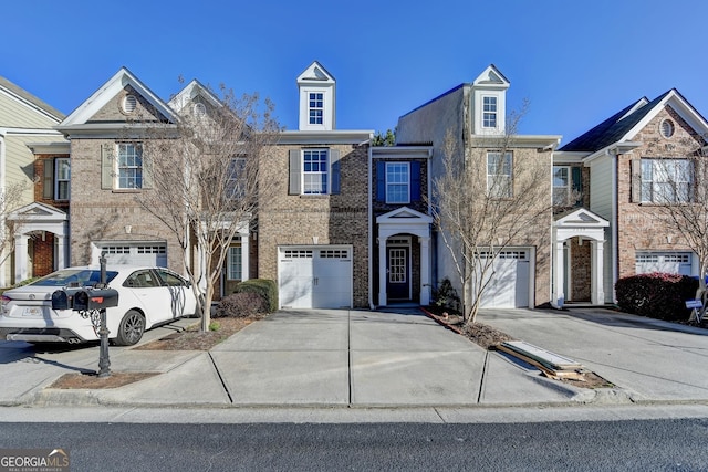 multi unit property with brick siding, driveway, and a garage