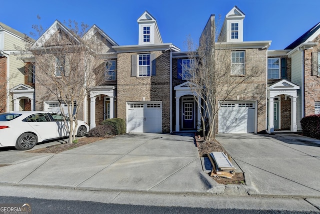 view of property with brick siding, concrete driveway, and an attached garage